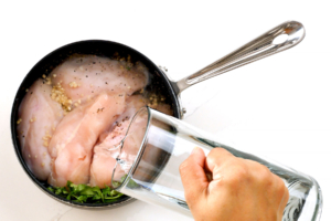 Agregando agua a la olla con pollo