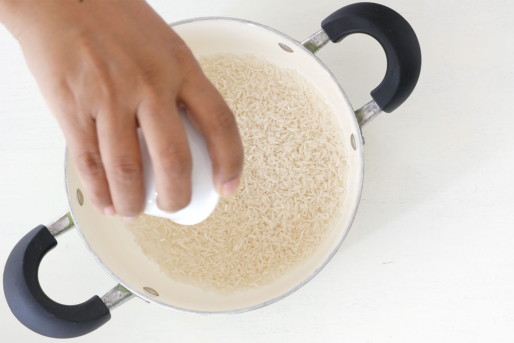 Agregando arroz a la olla.